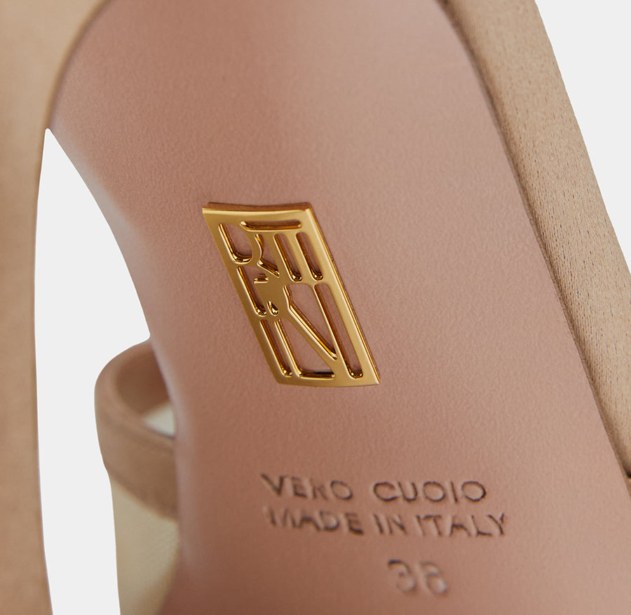 This is a close up of the gold decal on the back of a Britt Netta shoe. The decal is BRITT NETTAS signature emblem, which includes her initials "B" "N"  and a gemini symbol, which is housed inside of a rectangle.
